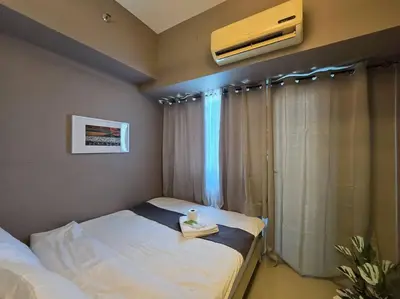 a small room with two beds and a window at 1BR Condotel with Balcony at SM Light Residences #LT10 in Manila