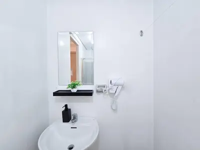 a white bathroom with a sink and a mirror at 1BR Condotel with Balcony at SM Light Residences #LT11 in Manila
