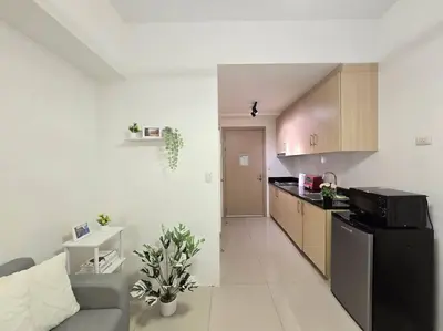 a kitchen and a living room with a couch and a counter at 1BR Condotel with Balcony at SM Light Residences #LT11 in Manila