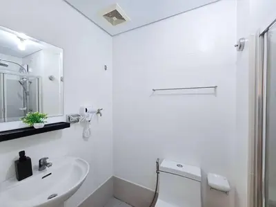 a white bathroom with a sink and a toilet at 1BR Condotel with Balcony at SM Light Residences #LT11 in Manila