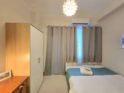 a small bedroom with a bed and a window at 1BR Condotel with Balcony at FAME Residences #FM62 in Manila