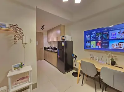 a kitchen with a dining table and a refrigerator at 1BR Condotel with Balcony at FAME Residences #FM62 in Manila