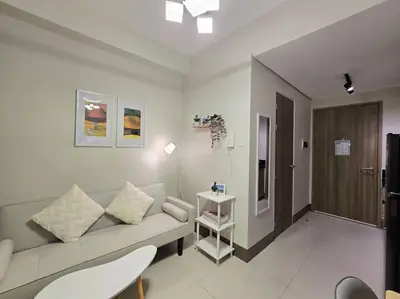 a living room with a couch and a table at 1BR Condotel with Balcony at FAME Residences #FM62 in Manila