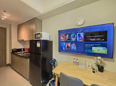 a kitchen with a black refrigerator and a table at 1BR Condotel with Balcony at FAME Residences #FM63 in Manila