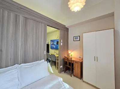 a bedroom with a bed and a desk with a computer at 1BR Condotel with Balcony at FAME Residences #FM63 in Manila