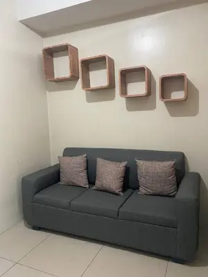 a blue couch in a room with three monitors on the wall at P3K Shell Staycation in Manila