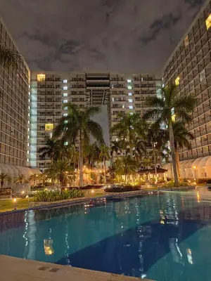 a large swimming pool in front of a city at night at P3K Shell Staycation in Manila