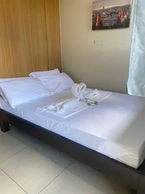 a bed with white sheets and towels on it at P3K Shell Staycation in Manila