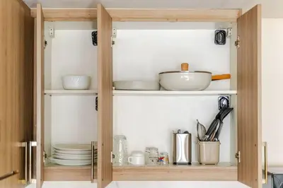 a cupboard filled with dishes and plates in a kitchen at 2Bedroom 2Bath near moa with Balcony facing pool in Manila