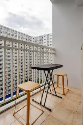 a table and two chairs on a balcony with a building at 2Bedroom 2Bath near moa with Balcony facing pool in Manila