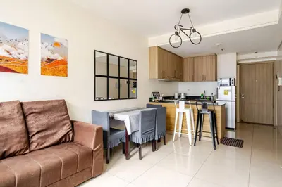 a living room with a couch and a kitchen at 2Bedroom 2Bath near moa with Balcony facing pool in Manila