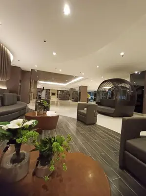 a living room with a couch and a table and chairs at 2Bedroom 2Bath near moa with Balcony facing pool in Manila