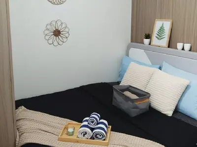 a bedroom with a bed with a tray of towels at Heart of Mall of Asia - Aseana Pasay in Manila
