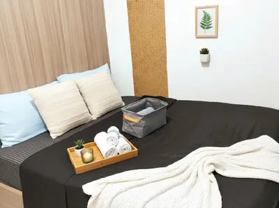 a bedroom with a bed with a tray of towels at Heart of Mall of Asia - Aseana Pasay in Manila