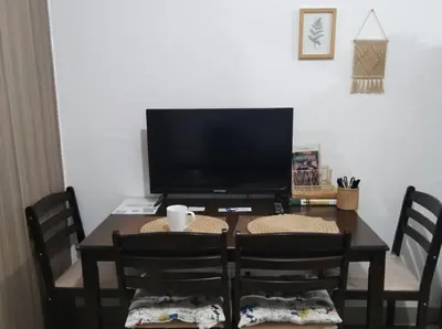 a dining room table with chairs and a television at Mall of Asia - Aseana Pasay Cheap Accommodation in Manila