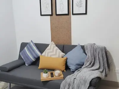 a couch with pillows and a blanket on it at Mall of Asia - Aseana Pasay Cheap Accommodation in Manila