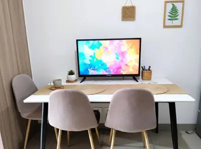 a computer monitor sitting on top of a desk with chairs at Mall of Asia - Aseana Pasay Cheap Accommodation in Manila