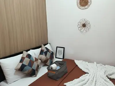 a bedroom with a bed with a blanket and pillows at Mall of Asia - Aseana Pasay Cheap Accommodation in Manila
