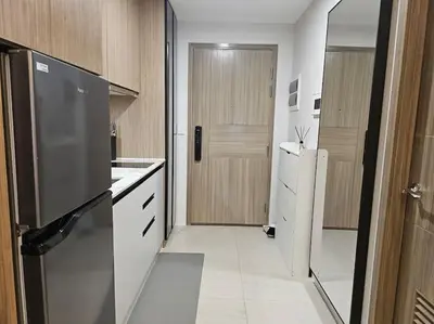 a small kitchen with a refrigerator and a door at Luxury Apartment at Park Mckinley West suite 2 in Manila