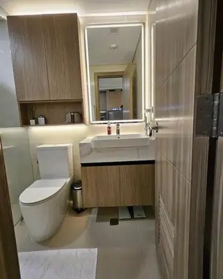 a bathroom with a toilet and a sink and a mirror at Luxury Apartment at Park Mckinley West suite 2 in Manila