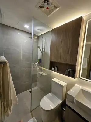 a bathroom with a toilet and a glass shower at Luxury Apartment at Park Mckinley West suite 2 in Manila