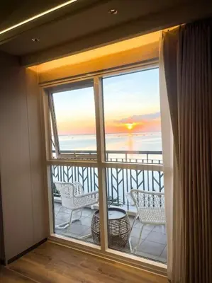 a room with a balcony with a view of the ocean at Luxury 1BR beside Okada Manila in Manila