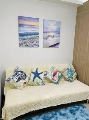 a couch with pillows on it in a living room at Ocean Room 677 Shore 2 Tower 3 MOA Complex, Pasay City in Manila