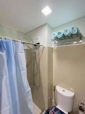 a bathroom with a shower and a toilet and towels at Ocean Room 677 Shore 2 Tower 3 MOA Complex, Pasay City in Manila