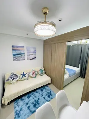 a room with a couch and a bed and a chandelier at Ocean Room 677 Shore 2 Tower 3 MOA Complex, Pasay City in Manila