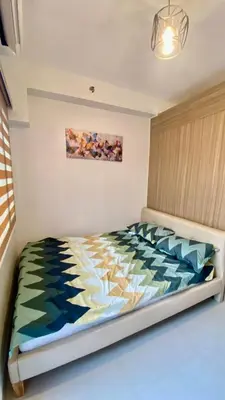 a bedroom with a bed with a colorful comforter at CASA ROSITA Staycation by 3MR in Manila