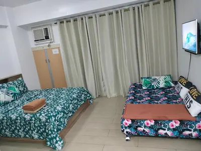 a small room with two beds and a window at Drew Condotel Across Airport Terminal 3 in Manila