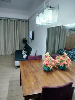 a living room with a table and a couch at Drew Condotel Across Airport Terminal 3 in Manila