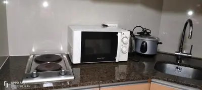a microwave oven sitting on top of a kitchen counter at Drew Condotel Across Airport Terminal 3 in Manila