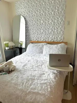 a bedroom with a bed with a laptop on it at M&M Azure Staycation Parañaque in Manila