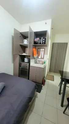 a bedroom with a bed and a kitchen with a table at Richard's Pad in Manila