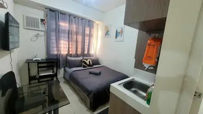 a small room with a bed and a sink at Richard's Pad in Manila