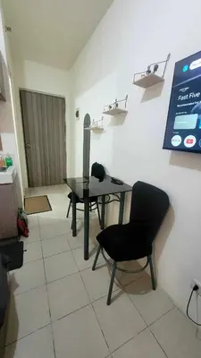 a room with a table and a chair and a screen at Richard's Pad in Manila