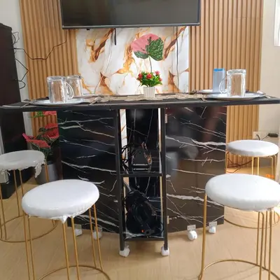 a black marble bar with three white stools at Sweet Stay at Manila in Manila