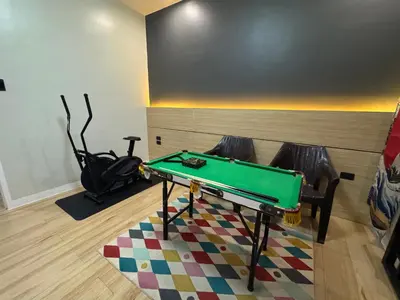 a ping pong table in a room with two chairs at MUJI TOWNHOUSE SUITE in Central Makati BILLIARDS, KTV in Manila