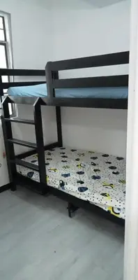 a bunk bed with a comforter on the bottom bunk at 2BR ENTIRE Familyhome near NAIA,MOA,BGC in Manila