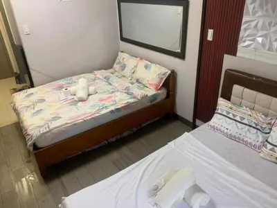 a bedroom with a bed with two stuffed animals on it at Ezekiel's Suites in Manila