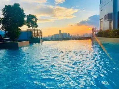a pool on the roof of a building with a sunset at Ezekiel's Suites in Manila