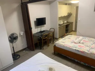 a bedroom with a bed and a desk with a computer at Ezekiel's Suites in Manila