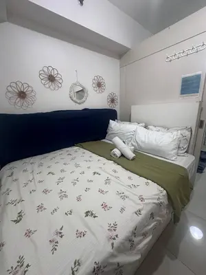 a bedroom with a large bed with flowers on it at Sea Residences Tower D, by Richnells in Manila