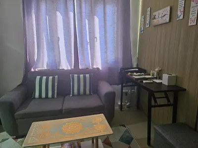 a living room with a couch and a table at BIG CUT, END UNIT in SHORE RESIDENCES in Manila