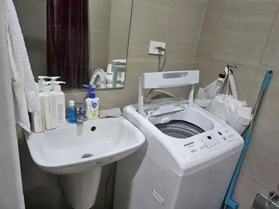 a bathroom with a washing machine and a sink at BIG CUT, END UNIT in SHORE RESIDENCES in Manila