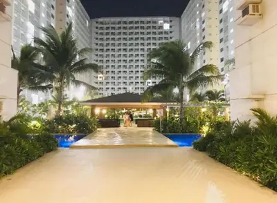 a view of a building with palm trees and a fountain at BIG CUT, END UNIT in SHORE RESIDENCES in Manila