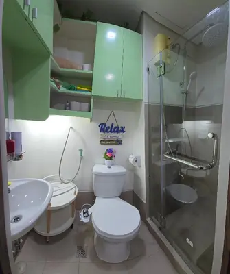 a bathroom with a toilet and a sink and a shower at SMDC Spring Resort Residences in Manila