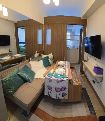 a living room with a couch and a table at SMDC Spring Resort Residences in Manila