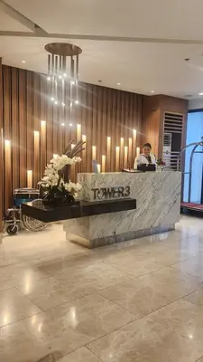 a man sitting at a counter in a hotel lobby at SMDC Spring Resort Residences in Manila